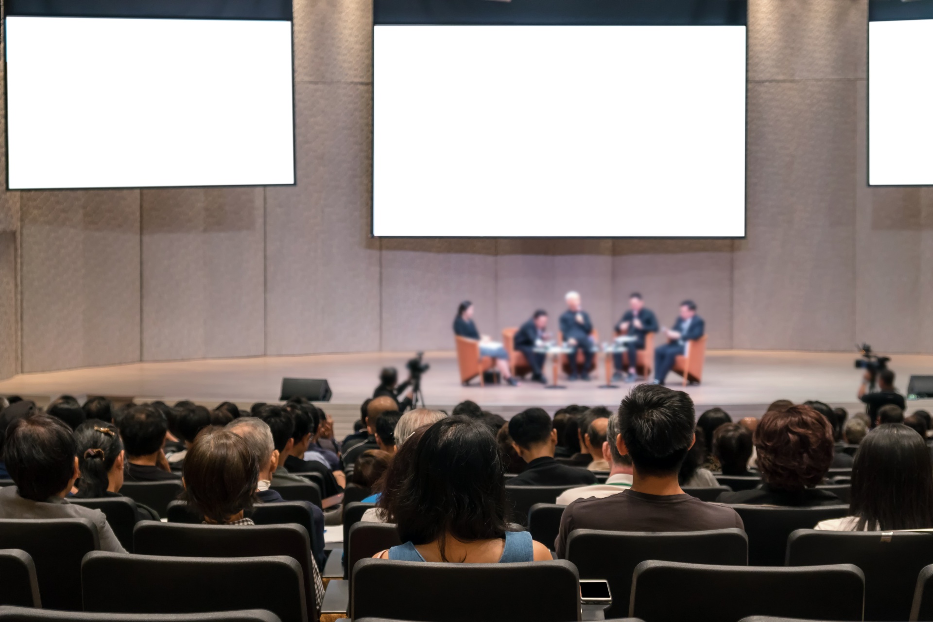 Rear view of Audience over the speakers on the stage in the conference hall or seminar meeting, business and education concept