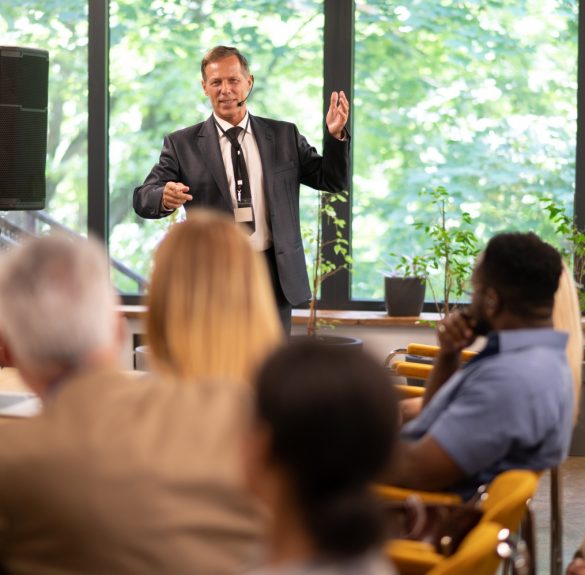 Cinematic image of a conference meeting. Business people sitting in a room listening to the motivator coach. Representation of a Self growth and improvement special event